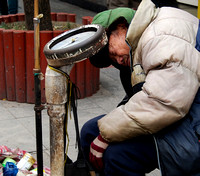 A homeless man at Confucius Temple begging with his weighing machine